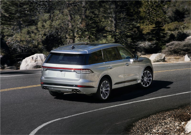 A 2023 Lincoln Aviator® Grand Touring model is shown being driven on a tight turn of a mountain road | Bill Knight Lincoln in Tulsa OK
